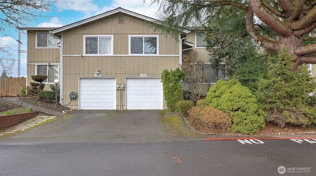 view of front of home with a garage, driveway, and fence