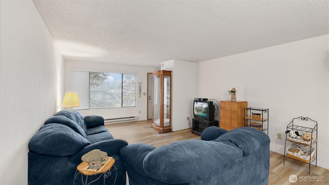 living area featuring baseboard heating, light wood-style flooring, and a textured ceiling