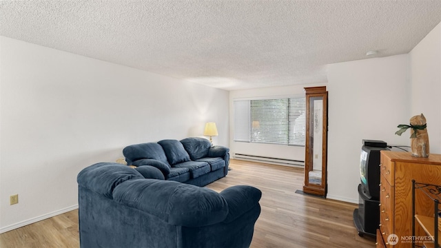 living room with a textured ceiling, light wood-type flooring, a baseboard heating unit, and baseboards