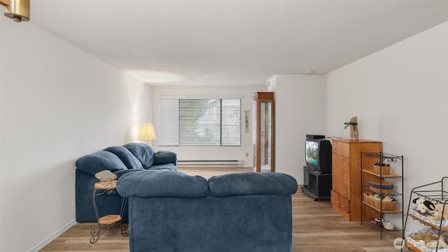 living room with a textured ceiling, light wood-style flooring, and a baseboard radiator