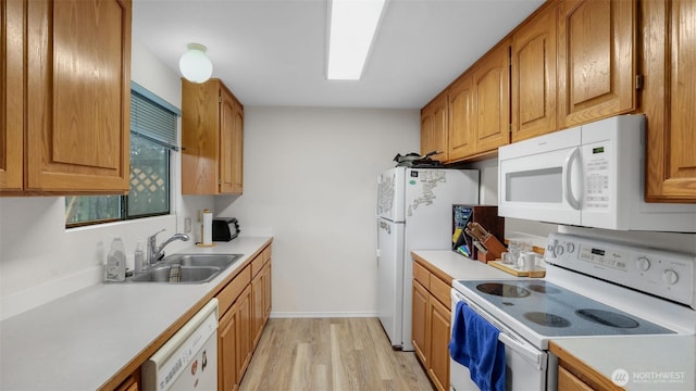 kitchen featuring white appliances, a sink, light countertops, light wood-style floors, and brown cabinets