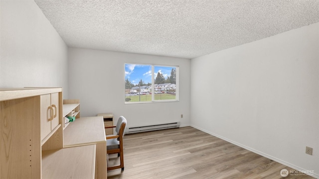 office area featuring light wood-style flooring, baseboards, baseboard heating, and a textured ceiling