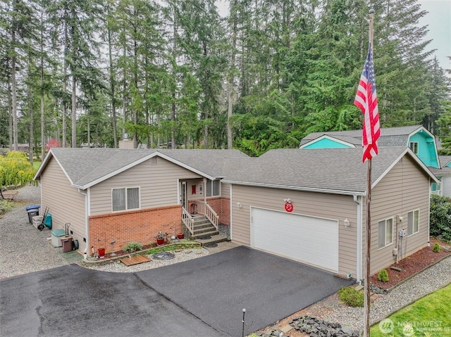 ranch-style home with an attached garage, brick siding, roof with shingles, and driveway