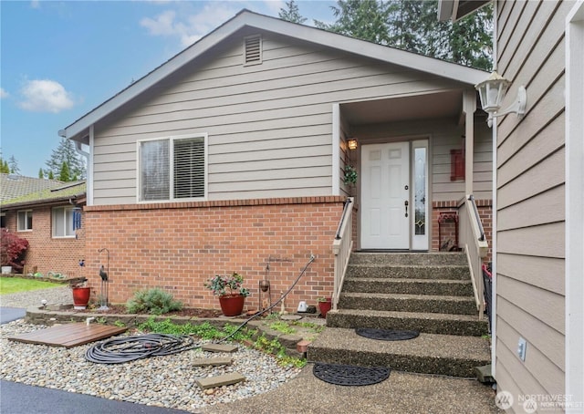 entrance to property featuring brick siding