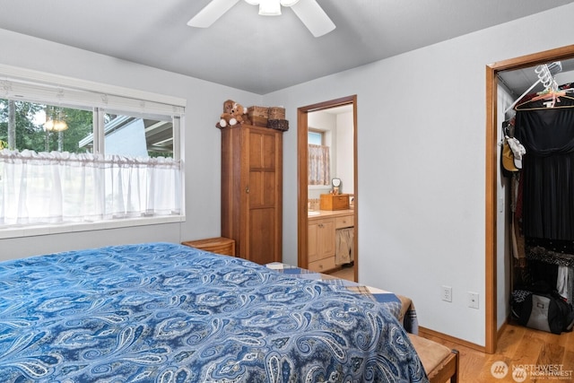 bedroom featuring a ceiling fan, wood finished floors, a closet, and ensuite bathroom