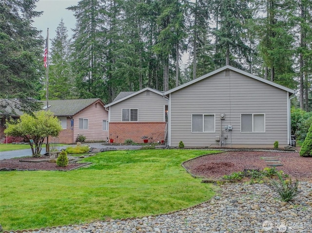 ranch-style home with brick siding and a front yard