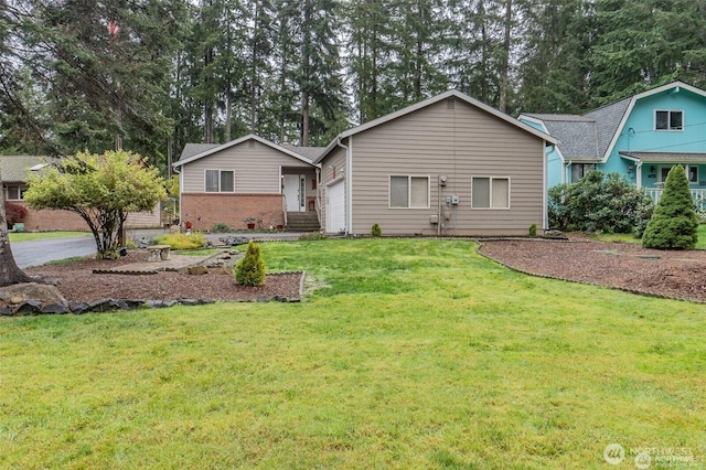 view of front of house with a garage, brick siding, and a front lawn