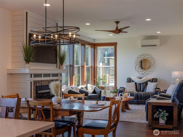 dining area featuring a wall mounted air conditioner, wood finished floors, recessed lighting, a fireplace, and ceiling fan