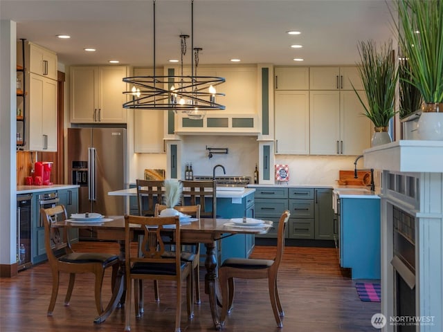 kitchen with backsplash, high end fridge, dark wood-style flooring, and hanging light fixtures