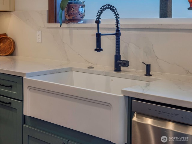 interior details with stainless steel dishwasher, light stone countertops, backsplash, and a sink