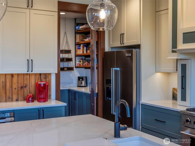 kitchen featuring light stone counters, white cabinetry, and stainless steel appliances