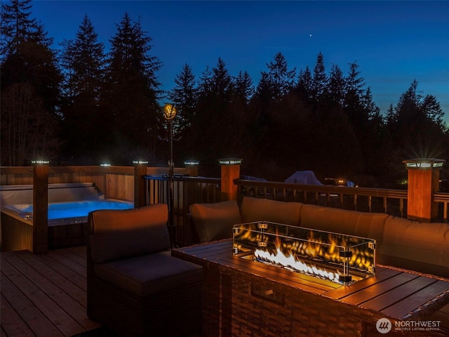 deck at night featuring a fire pit