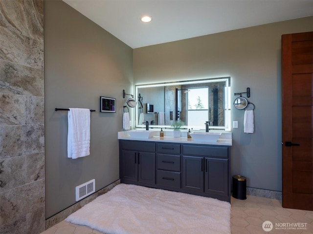 bathroom with a sink, visible vents, recessed lighting, and double vanity