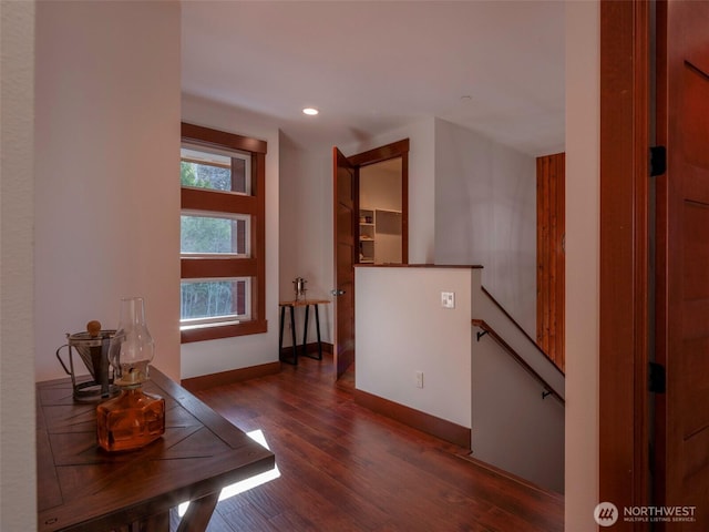 corridor with recessed lighting, baseboards, an upstairs landing, and wood finished floors