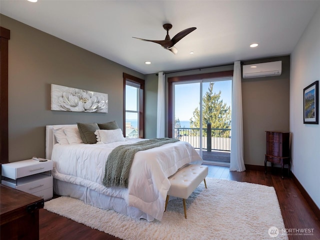 bedroom featuring a wall unit AC, wood finished floors, baseboards, recessed lighting, and access to outside