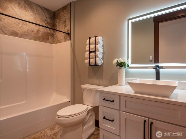 bathroom featuring toilet, shower / washtub combination, and vanity