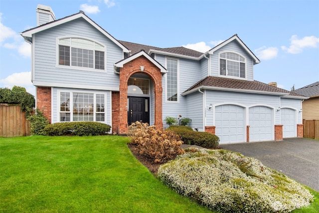 view of front of property featuring brick siding, fence, aphalt driveway, a front yard, and an attached garage