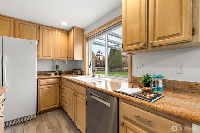 kitchen with a sink, freestanding refrigerator, recessed lighting, light wood finished floors, and dishwasher