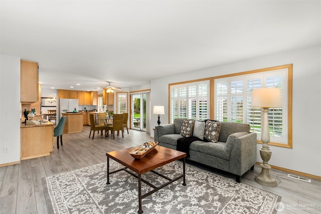 living area featuring light wood-type flooring, visible vents, recessed lighting, baseboards, and ceiling fan