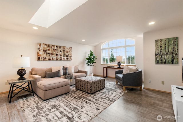 living area featuring a skylight, recessed lighting, and wood finished floors