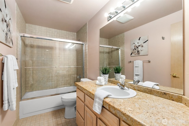 full bath featuring vanity, toilet, tile patterned flooring, and shower / bath combination with glass door