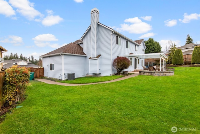 rear view of house with a pergola, a patio, fence, cooling unit, and a yard