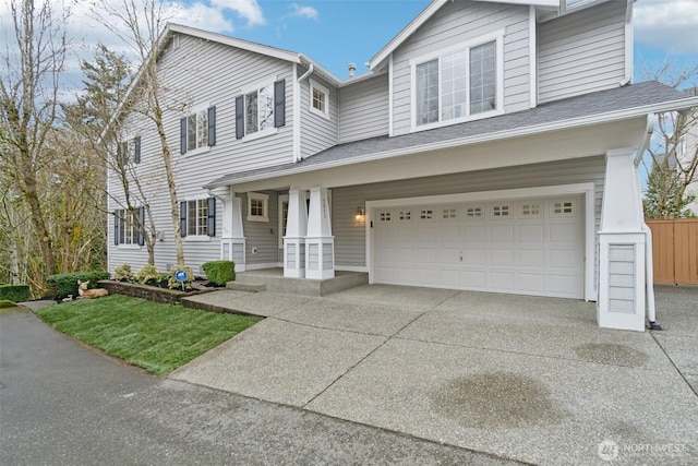 traditional-style home featuring covered porch, a garage, and driveway