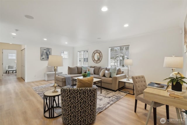 living room with recessed lighting, baseboards, and light wood-style floors