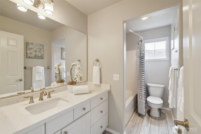 bathroom featuring shower / tub combo with curtain, toilet, and vanity