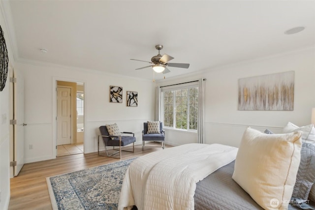 bedroom with a ceiling fan, crown molding, baseboards, and light wood-type flooring