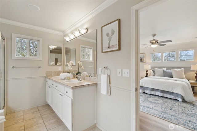 ensuite bathroom featuring a wainscoted wall, connected bathroom, crown molding, ceiling fan, and vanity