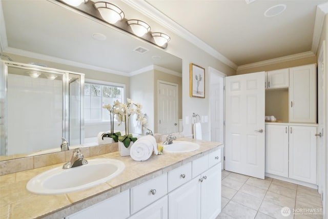 bathroom with visible vents, a stall shower, crown molding, and a sink