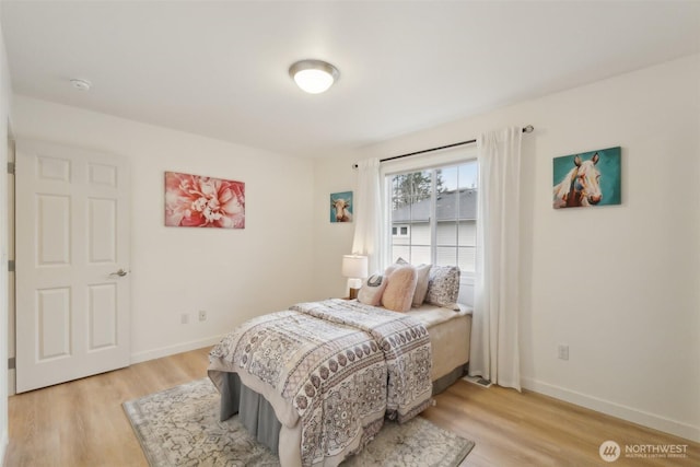 bedroom with baseboards and light wood-style flooring