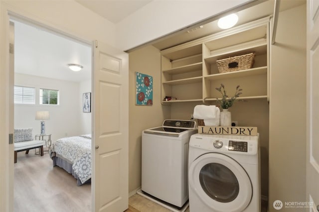 laundry room featuring light wood-style floors, washing machine and dryer, and laundry area