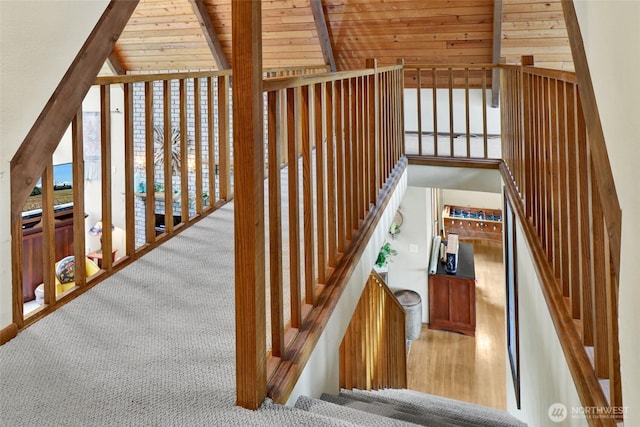 staircase featuring expansive windows, wood finished floors, carpet, wood ceiling, and vaulted ceiling with beams