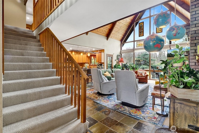 living area featuring wood ceiling, stairs, stone tile floors, an inviting chandelier, and high vaulted ceiling