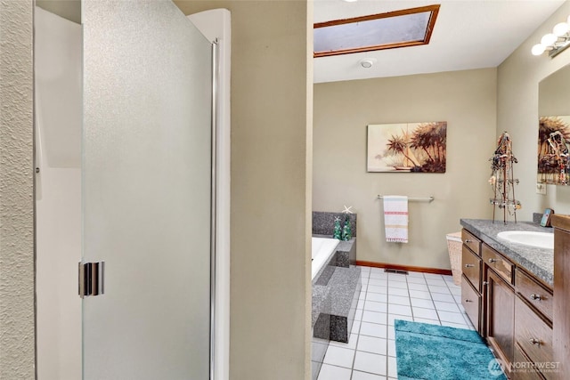 bathroom featuring vanity, baseboards, a stall shower, tile patterned flooring, and a garden tub