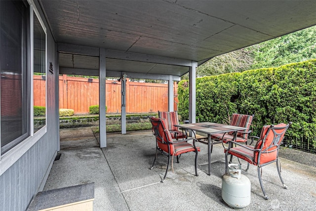 view of patio featuring outdoor dining space and fence