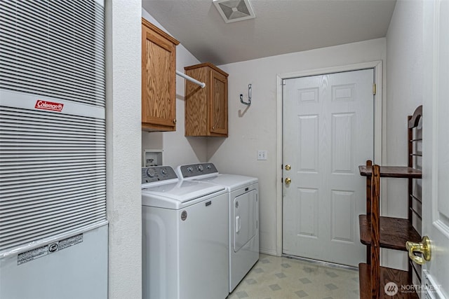 clothes washing area featuring visible vents, cabinet space, light floors, and washing machine and dryer