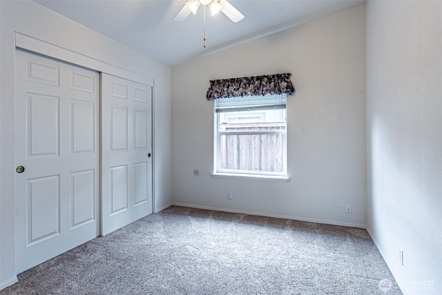 unfurnished bedroom featuring a closet, carpet floors, lofted ceiling, and ceiling fan