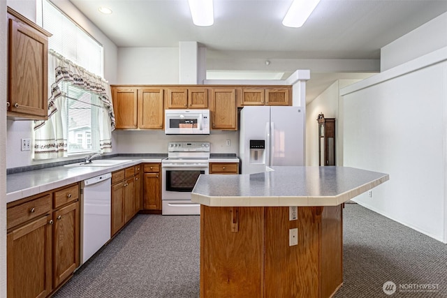 kitchen with a sink, white appliances, a kitchen island, and brown cabinetry