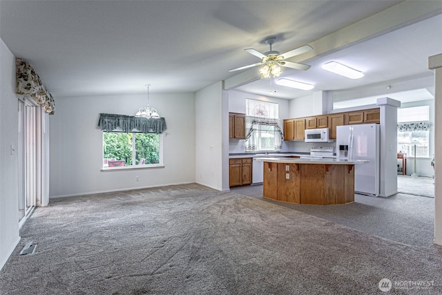 kitchen with white appliances, brown cabinetry, lofted ceiling, carpet flooring, and a center island