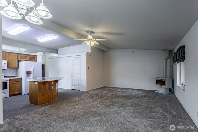 kitchen featuring a ceiling fan, heating unit, open floor plan, white appliances, and a wood stove