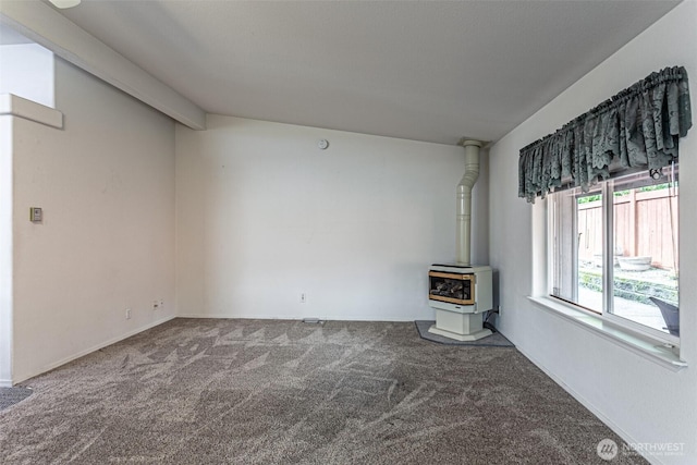 unfurnished living room featuring a wood stove and carpet