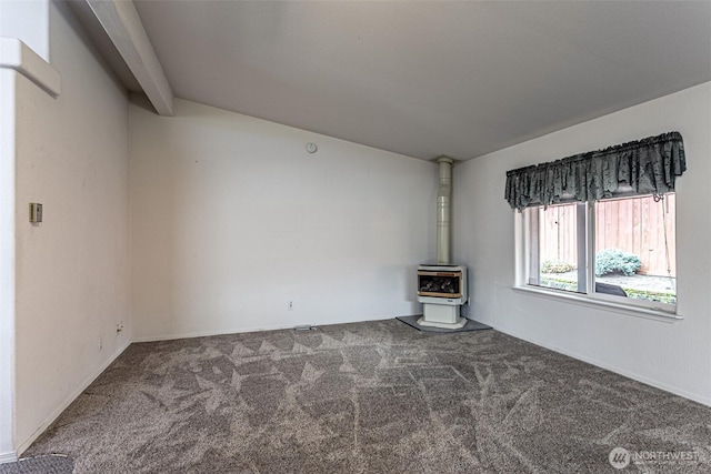 carpeted empty room featuring a wood stove