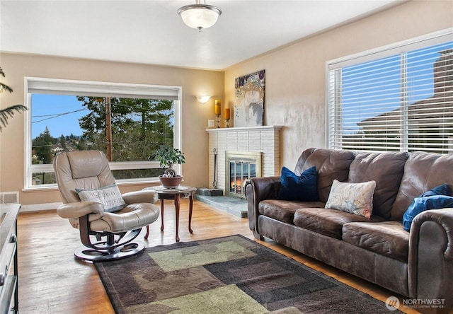 living room featuring a wealth of natural light, a fireplace, and wood finished floors