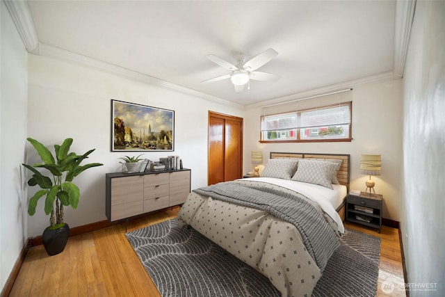 bedroom with light wood-style flooring, ceiling fan, baseboards, and ornamental molding