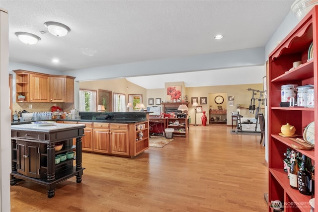 kitchen with decorative backsplash, open shelves, a peninsula, and light wood-type flooring