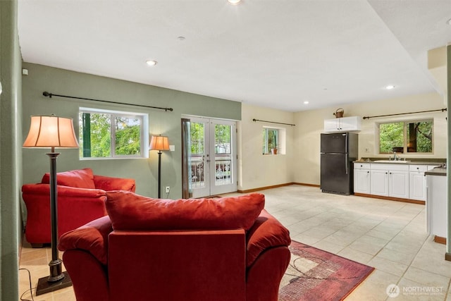 living room with recessed lighting, light tile patterned floors, french doors, and baseboards