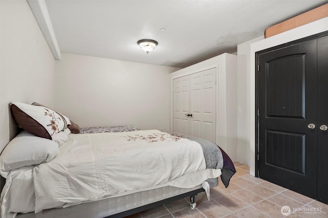 bedroom featuring light tile patterned floors and a closet